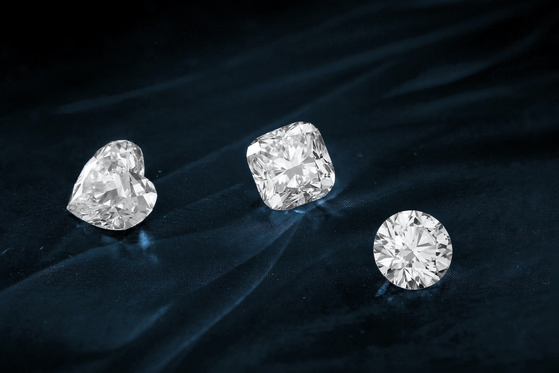 Loose brilliant-cut diamonds resting on dark silk